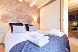 sypialnia z białym łóżkiem i ręcznikami w obiekcie Friendly Rentals Santa Monica w Barcelonie