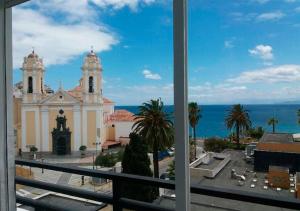 a view of a church and the ocean from a window at Parador de Ceuta in Ceuta