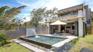 a backyard with a swimming pool and a house at Stylia Villas in Trou dʼ Eau Douce