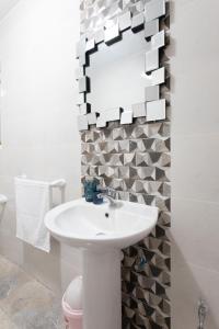 a bathroom with a white sink and a mirror at F5 Modern and Bright Apartment in Malta in Msida