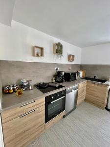een keuken met houten kasten en een fornuis met oven bij La Romantica**** 4/6 Pers 5kms de Nausicaa in Saint-Étienne-au-Mont