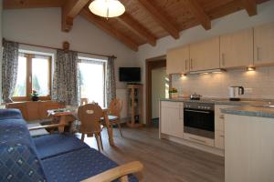 a kitchen and living room with a couch and a table at Fluchthäusl Ferienwohnung in Ramsau +8 photos