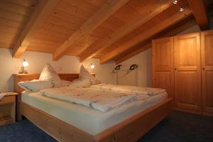 Cama grande en habitación con techo de madera en Fluchthäusl Ferienwohnung en Ramsau