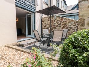 a patio with two chairs and an umbrella at 2 Dartmouth House in Dartmouth