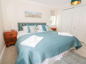 a bedroom with a large bed with a blue blanket at 2 Dartmouth House in Dartmouth