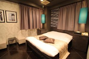 a bedroom with a bed with two pillows on it at Hotel K Omiya (Adult Only) in Saitama