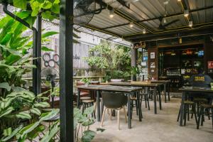Un restaurante con mesas, sillas y plantas. en Gord ChiangMai Hotel, en Chiang Mai