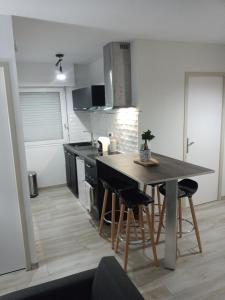 uma cozinha com mesa e cadeiras num quarto em L'annexe em Courseulles-sur-Mer