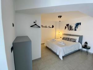 1 dormitorio con cama blanca y mesa en MenoUno House en Crispiano