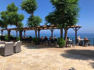 eine Gruppe von Personen, die an Tischen unter einer Pergola sitzen in der Unterkunft High Life in Kyrenia