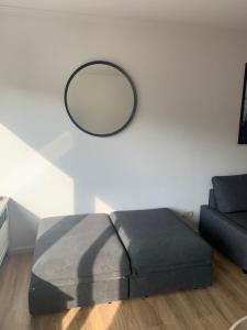 een spiegel aan een muur naast een bank bij Les galets in Middelkerke