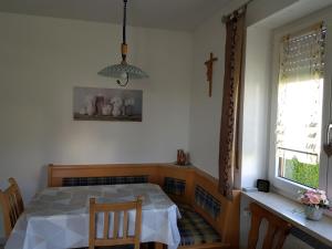 a dining room with a table and a cross on the wall at Ferienwohnung Landhausfeeling in Bad Abbach +6 photos