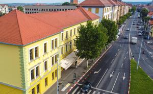 een uitzicht op een straat met een geel gebouw bij JOYME Hotel in Sibiu