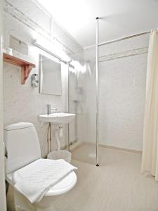 a white bathroom with a toilet and a sink at Hotell Fjället in Björkliden