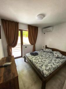 ein Schlafzimmer mit einem Bett, einem Tisch und einem Fenster in der Unterkunft Vila Levitas in Dubova