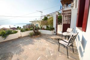 un patio con mesa y sillas en un edificio en Aquarella-Fairytale Apartment with Sunset View, en Poros