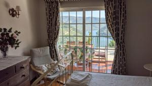 a bedroom with a bed and a large window at Quinta da Galeira in Pinhão