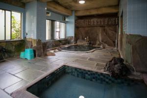 a large bathroom with a tub in the middle at Seisenso in Nozawa Onsen