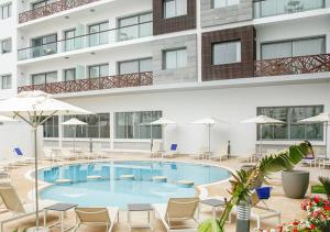 - une piscine en face d'un bâtiment avec des chaises et des parasols dans l'établissement Zephyr Agadir, à Agadir