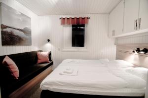 ビヨルクリーデンにあるコッパス キャビン ビレッジのベッド1台とソファが備わる小さな客室です。