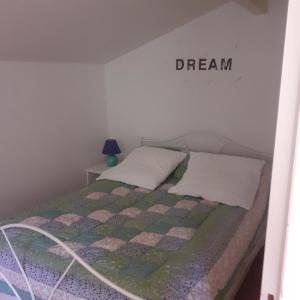 Una cama en una habitación con una señal de sueño en la pared en UR ONDOAN - Appartement Saint Pée sur Nivelle en Saint-Pée-sur-Nivelle