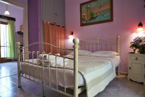 een slaapkamer met een bed en paarse muren bij Antigoni Apartments in Parga