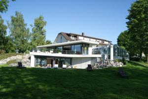 a house on a hill with a green lawn at Hotel-Restaurant Schwedi in Langenargen