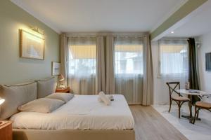 a bedroom with a bed and a table and windows at Charming studio near Tour Eiffel Invalides Beaugrenelle in Paris