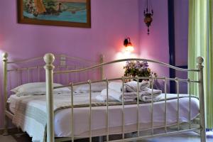 een slaapkamer met een wit bed en roze muren bij Antigoni Apartments in Parga