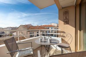 einen Balkon mit einem Tisch und Stühlen in der Unterkunft Quartier Vauban 2 bedroom apartment in Antibes