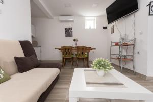 ein Wohnzimmer mit einem Sofa und einem Tisch in der Unterkunft Apartmani kod Marka in Požega