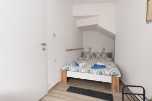 a small bedroom with a bed and a chair at Apartmani kod Marka in Požega