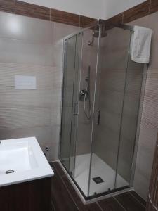 a shower with a glass door next to a sink at Scilla Upper Town in Scilla
