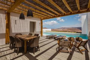 a patio with a table and chairs and a pool at Amarelo Suites in Klouvas