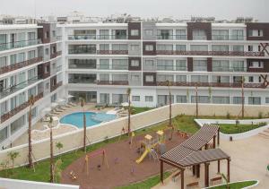 un complesso di appartamenti con parco giochi di fronte a un edificio di Zephyr Agadir ad Agadir