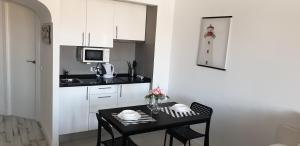 a small kitchen with a table with chairs and a counter at Cascais Ocean View 3 in Cascais
