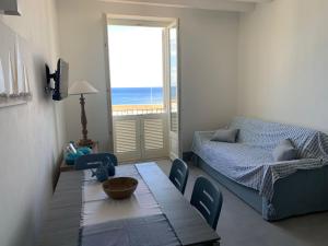 a living room with a table and a bed and a window at Appartamenti Marina Corta in Lipari