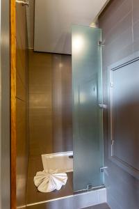 La salle de bains est pourvue d'une cabine de douche en verre et d'une serviette. dans l'établissement ONOMO Hotel Rabat Medina, à Rabat