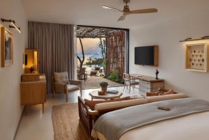 a bedroom with two beds and a living room at Six Senses Ibiza in Portinatx