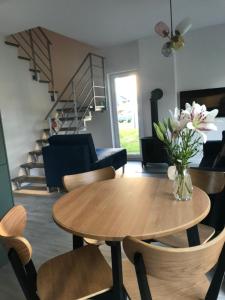 een woonkamer met een houten tafel en stoelen bij Domek Pod Sosnami in Rozewie +8 foto's