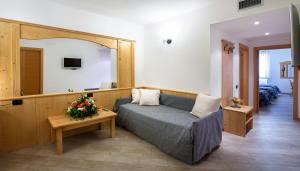 Hotel Ristorante Alla Nave في لافيس: غرفة معيشة مع أريكة ومرآة