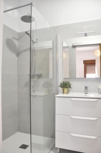 een witte badkamer met een douche en een wastafel bij Ca Tía Teresa in Denia