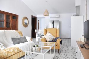 una sala de estar con un sofá y sillas en Ca Tía Teresa, en Denia