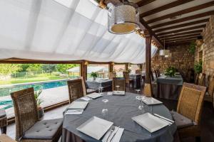 a dining room with a table and a swimming pool at Complejo Puente Romano in Entrambasaguas