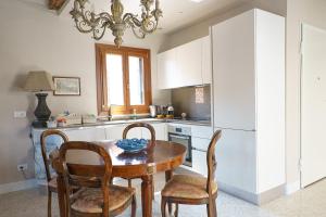 a kitchen with a table and chairs and a refrigerator at Palazzo Veneziano direct at the canal with roof terrace in Venice