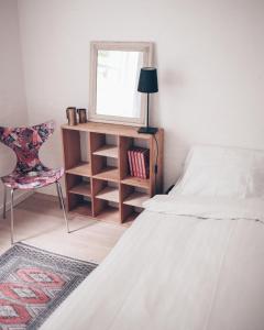 a bedroom with a bed and a mirror and a chair at Skovsted - Himmelbjerggården in Ry