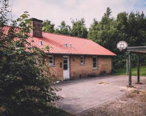 a brick building with a red roof and a basketball hoop at Skovsted - Himmelbjerggården in Ry