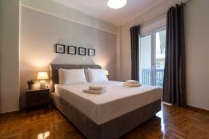 a bedroom with a large bed and a large window at Acropolis View 2BD Apt next to Museum & Metro in Athens