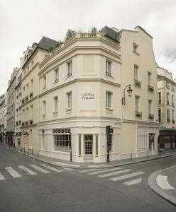 un gran edificio blanco en la esquina de una calle en Château Voltaire en París