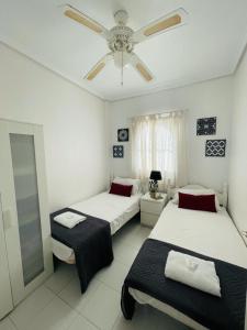 a room with two beds and a ceiling fan at Casa Linda in Rojales +43 photos